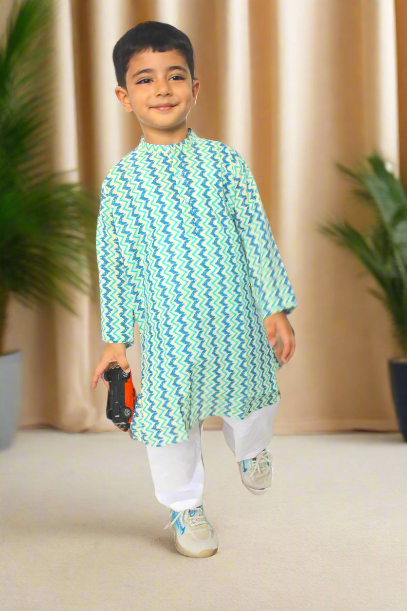 Child wearing a green and white patterned kurta with white pants on a white background