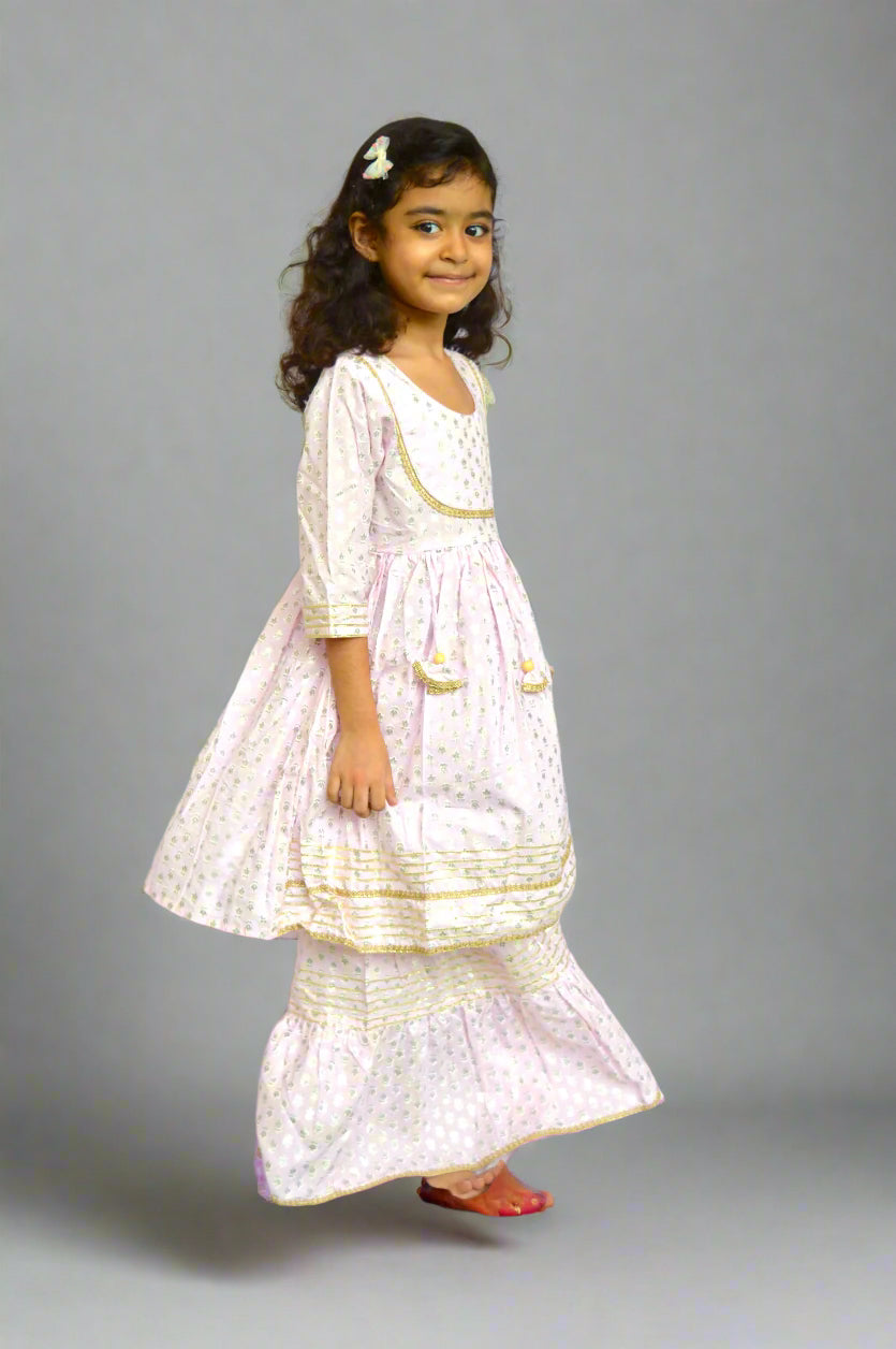 Young girl in a lilac traditional outfit with gold details foil print against a white background