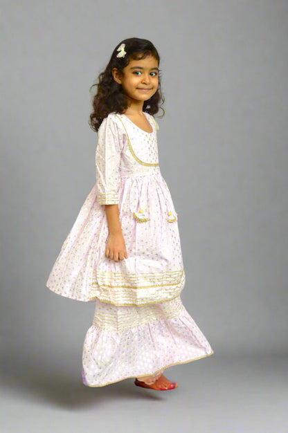 Young girl in a lilac traditional outfit with gold details foil print against a white background