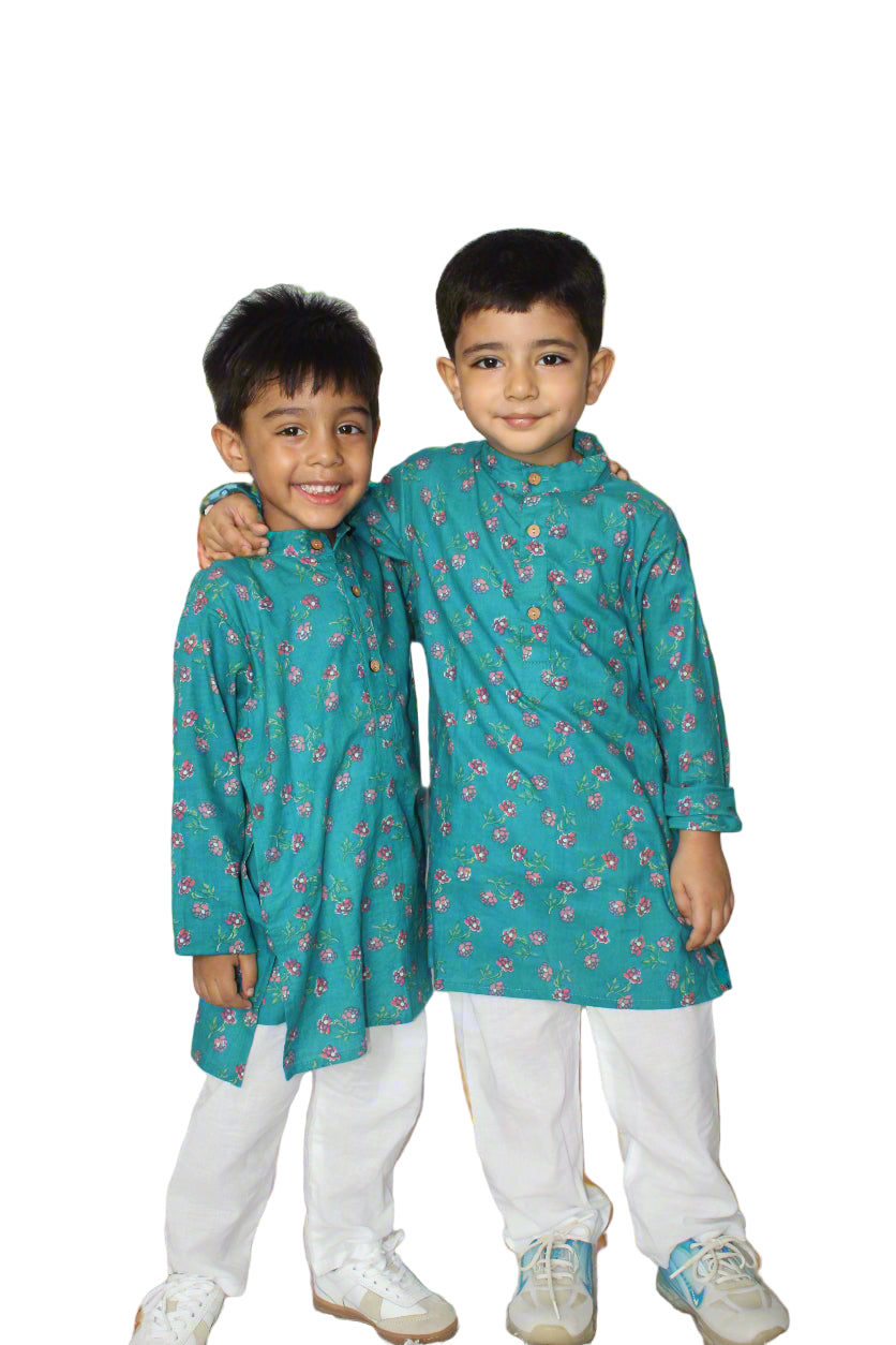 Two children wearing matching teal traditional outfits twinning boys