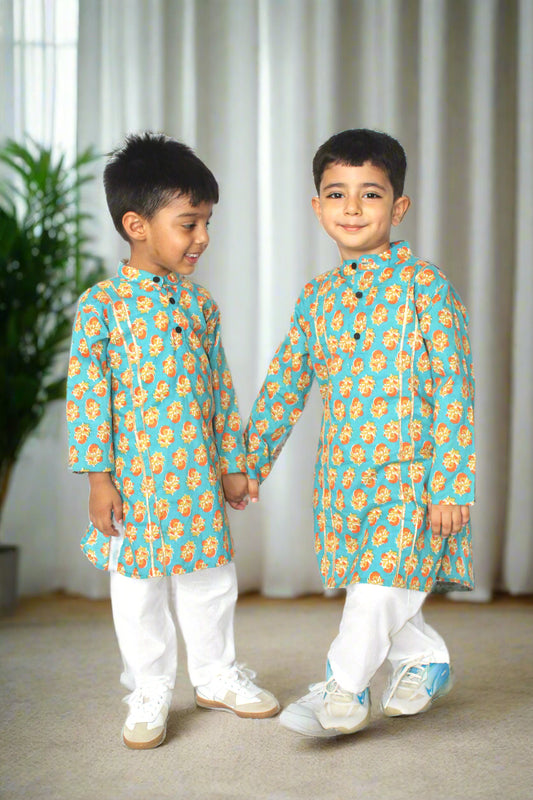Two children wearing matching traditional outfits with floral patterns on a white background
