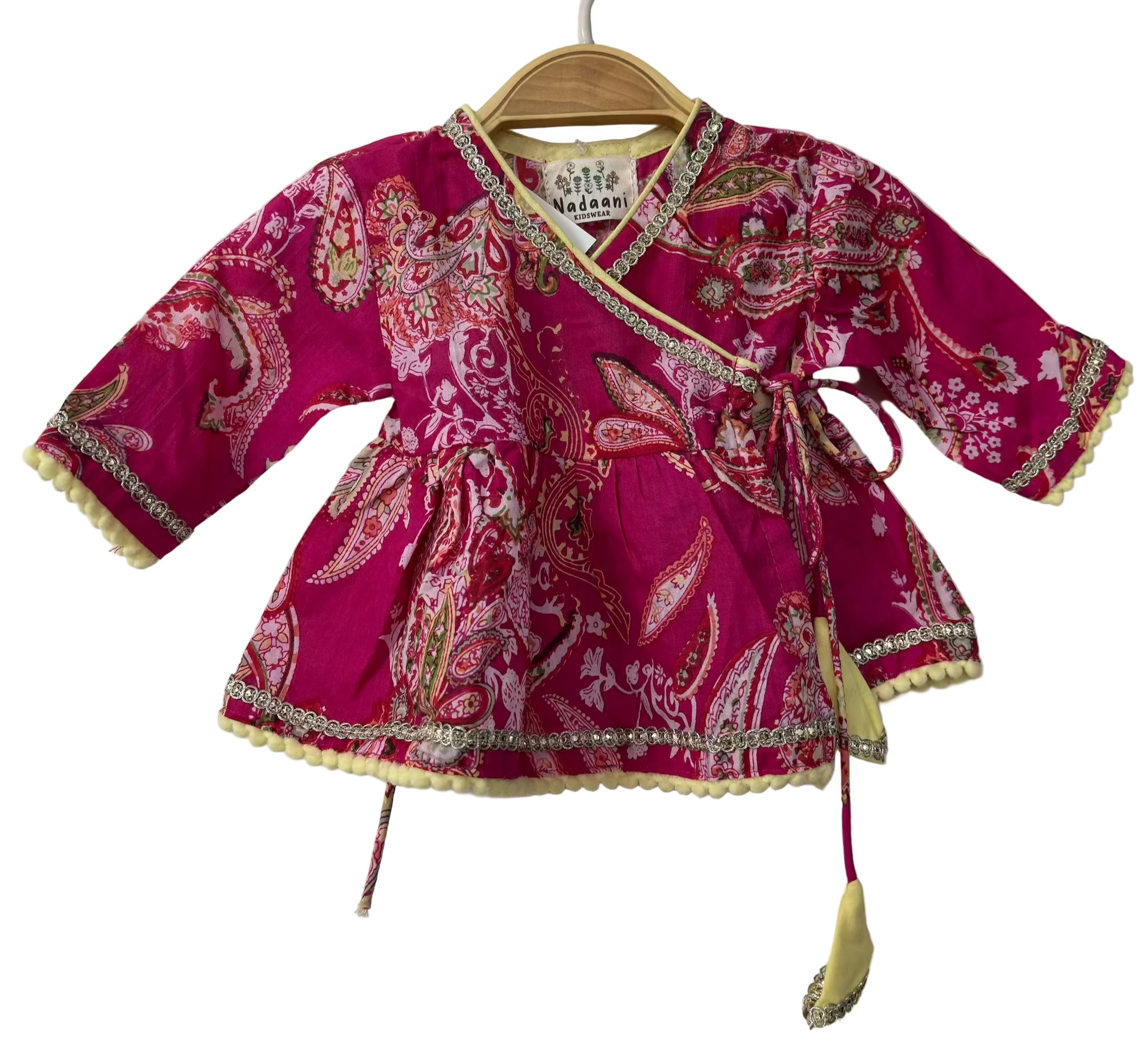 Pink patterned baby dress on a hanger against a white background