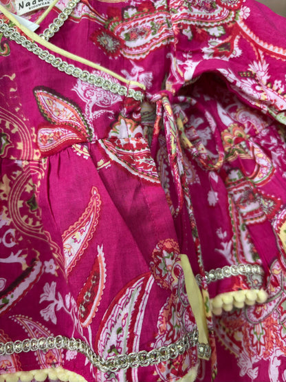 Close-up of a pink patterned garment with decorative elements.
