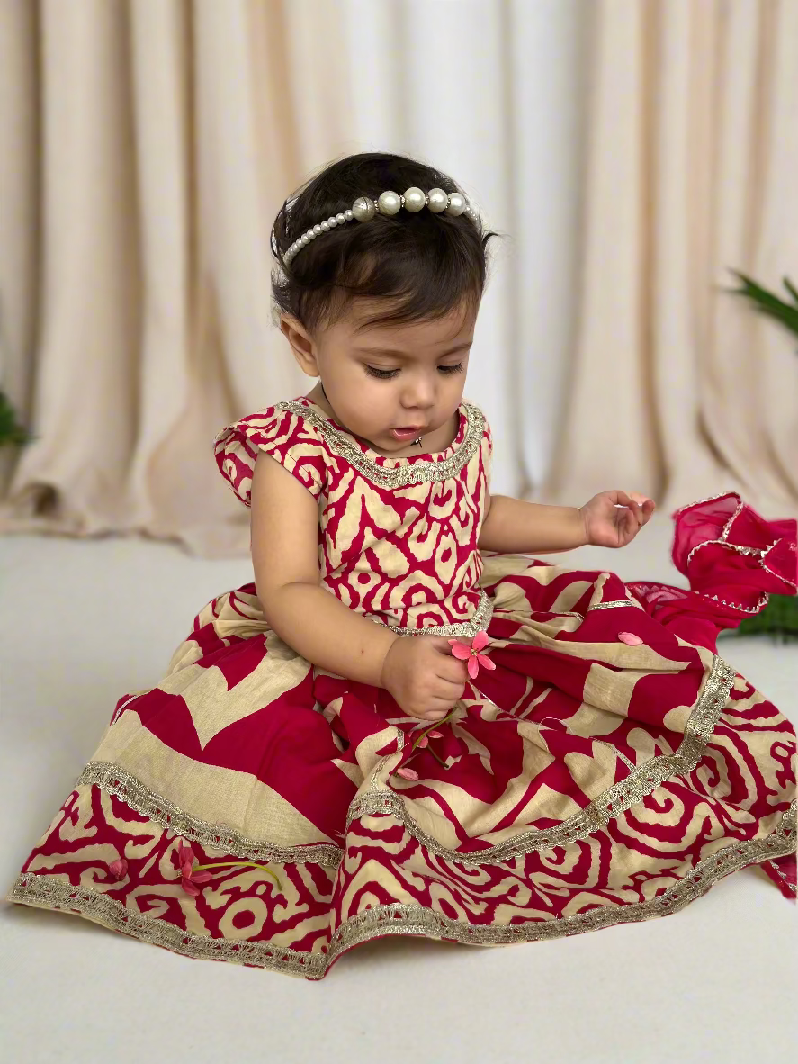 Child wearing a red and beige traditional outfit on a white background